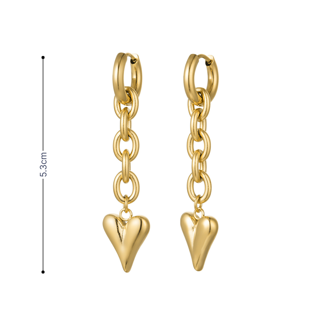 Detail van gouden oorringetjes met schakelketting en glanzend hartje