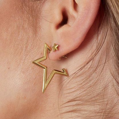 Gouden open ster oorknopje gedragen in het oor