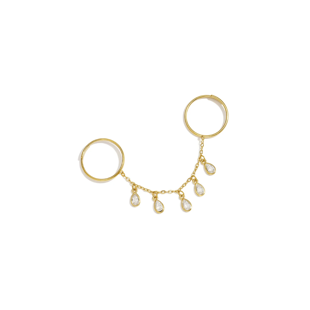 Gouden ring handchain met twee verbonden ringen, een fijne gouden schakelketting en vijf hangende druppelvormige strass bedels met heldere steentjes op witte achtergrond.