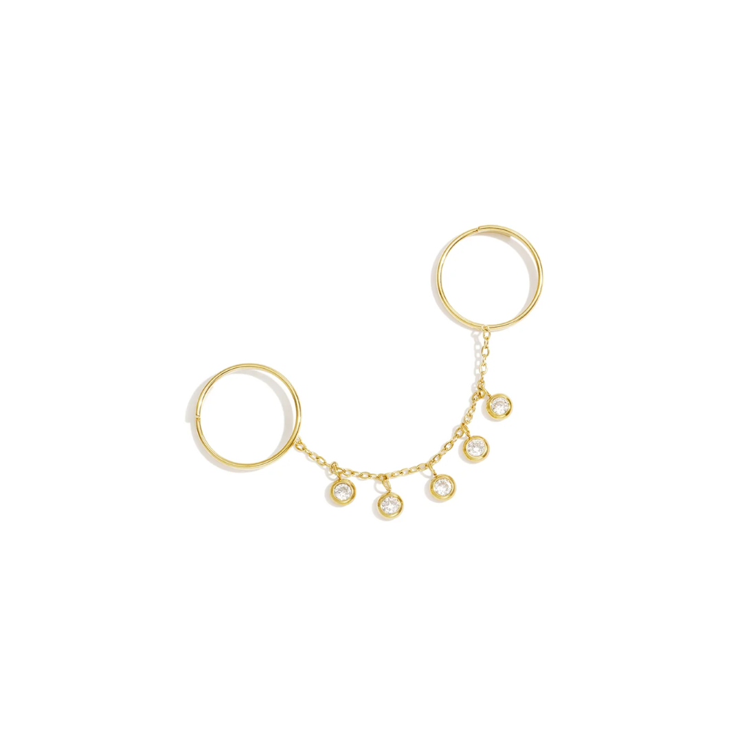 Gouden ring handchain met twee verbonden ringen, een fijne gouden schakelketting en vijf ronde strass bedels met heldere steentjes op een witte achtergrond.