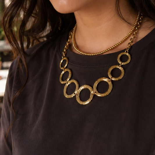 Gouden kettingenset van Casa Jadel met een fijne goudkleurige kralenketting en een statement ketting met grote open cirkels.