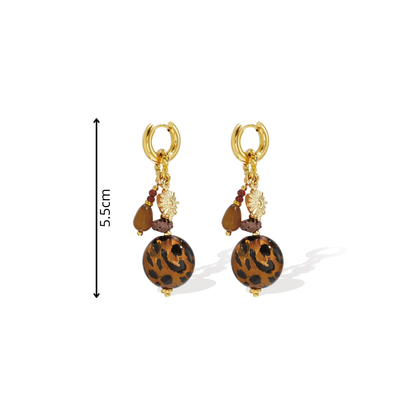 Gouden statement oorringen met grote amberkleurige panterprint kralen, bruine hangers, bordeauxrode kraaltjes en gouden bloembedeltjes afmeting