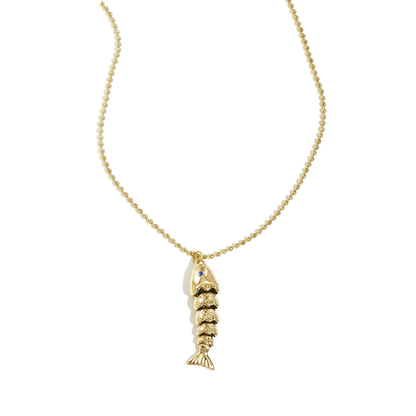 Gouden ketting met gedetailleerde vis bedel aan fijne bolletjesketting op lichte achtergrond.