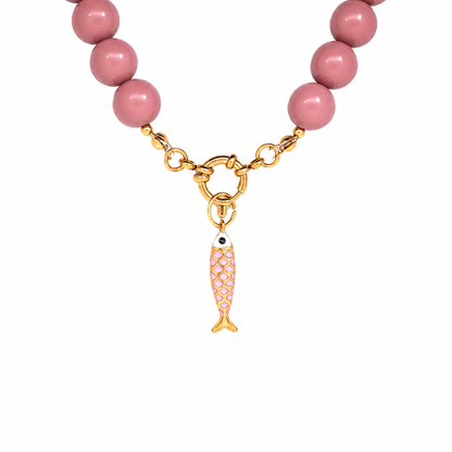 Gouden vis bedel met roze schubben hangend aan boeislot roze kralenketting Maud. 