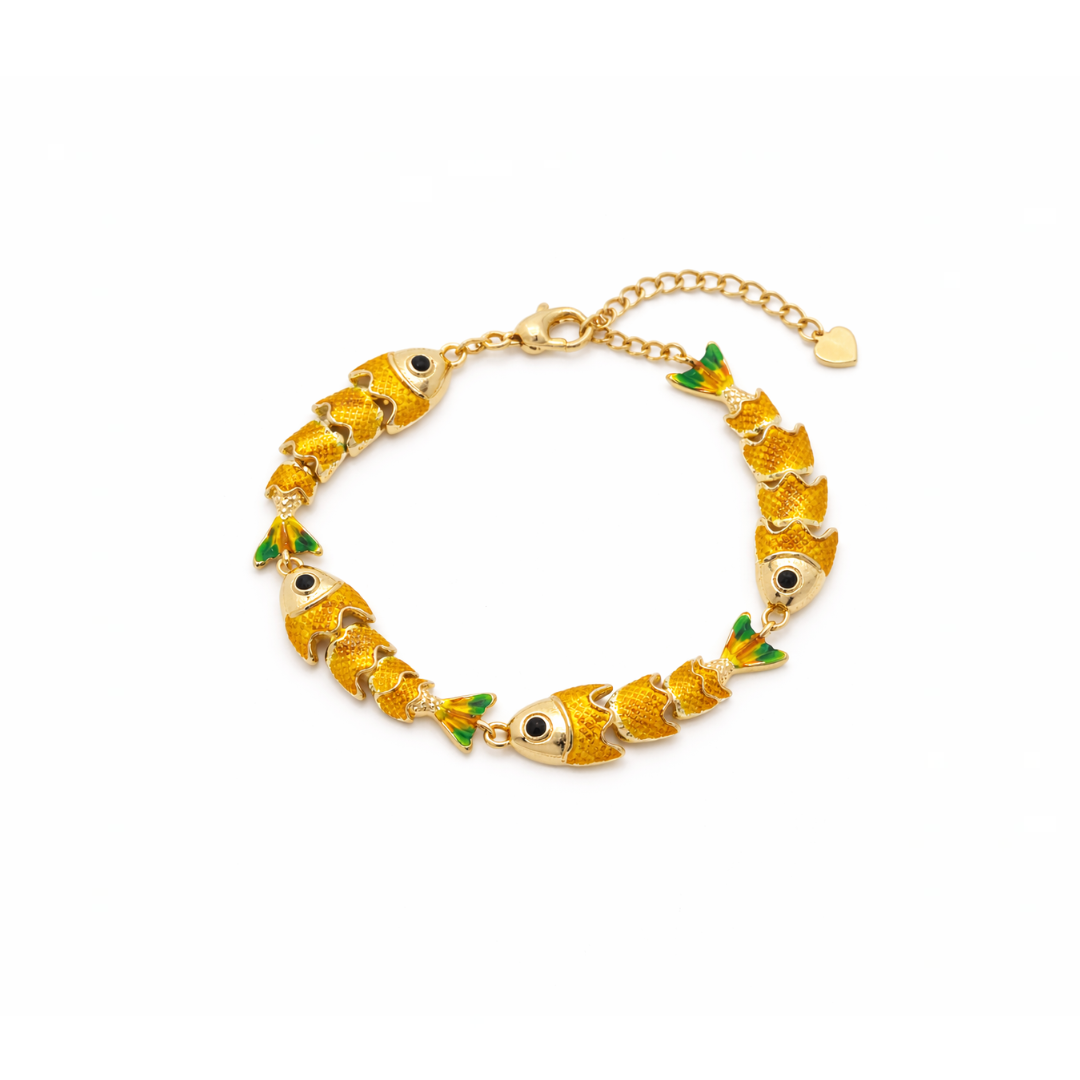 Gouden visjes armband met groene accenten en speels design op lichte achtergrond.