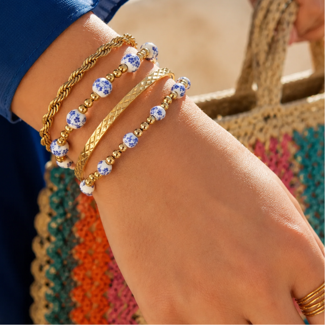 arm met Gouden kralenarmband met wit-blauwe porseleinlook kralen van Casa Jadel.