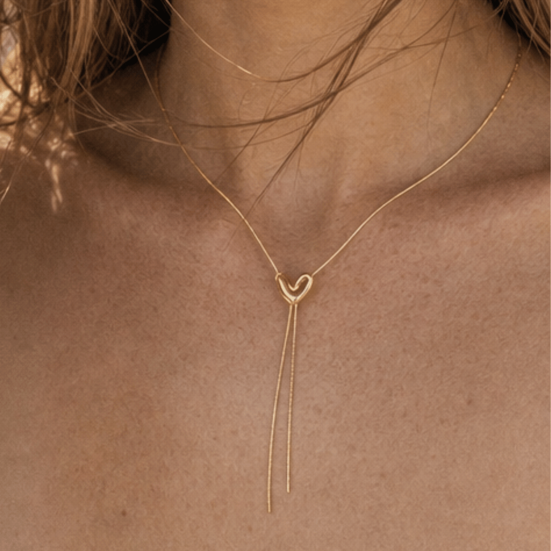 Model draagt goudkleurige Y-ketting met hart detail van Casa Jadel