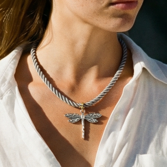 Model draagt grijze rope ketting met zilveren libelle bedel.
