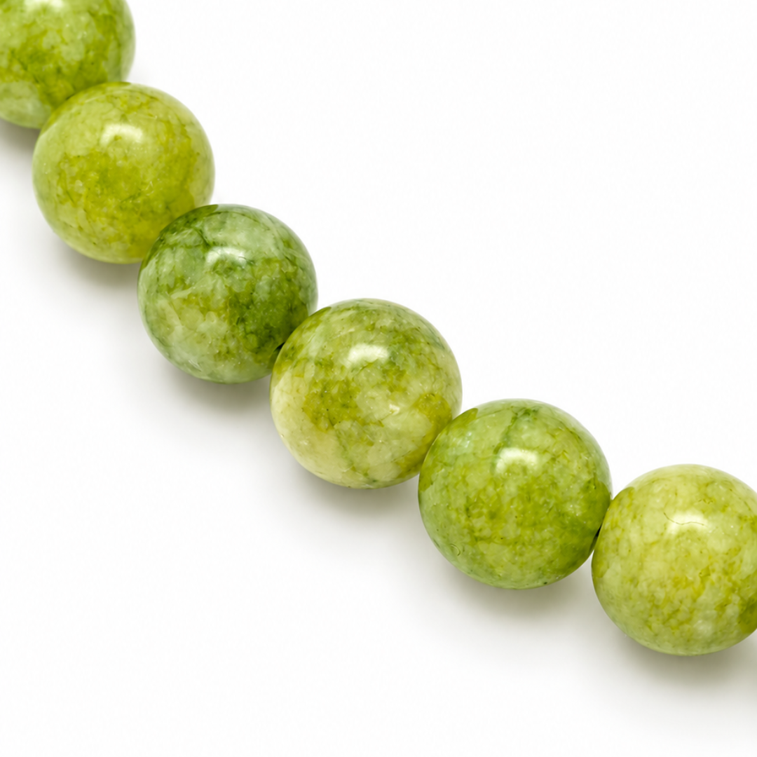 Detail van de ronde groene aventurijn kralen van ketting Kiki, met lichte en donkere groentinten en een gemêleerde tekening.