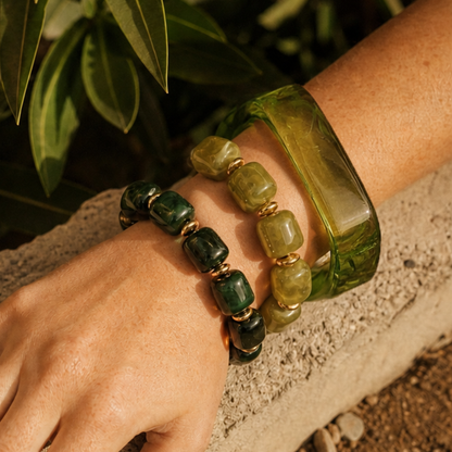 Arm met groene chunky resin armbanden en transparante groene bangle in zomerse Casa Jadel stijl