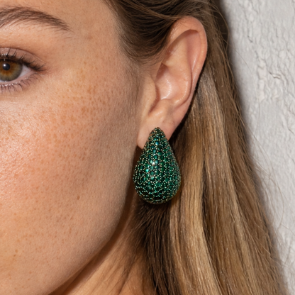 Groene diamand glitter oorbel in druppelvorm gedragen door model.