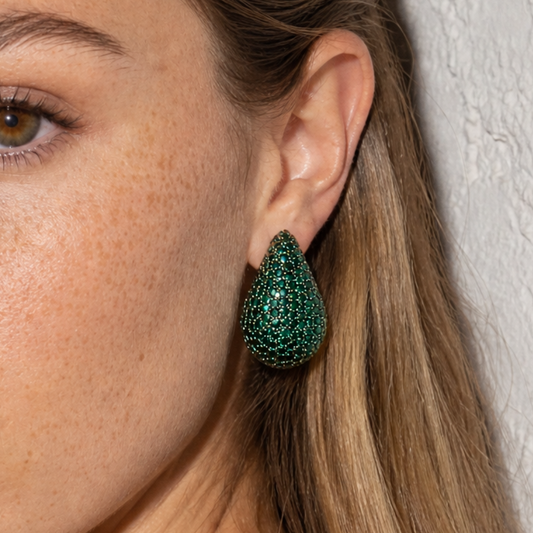Groene diamand glitter oorbel in druppelvorm gedragen door model.