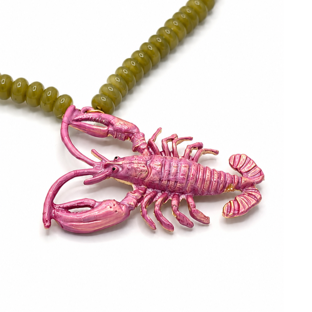 Close up van groene lange kralenketting met roze metallic kreeftbedel van Casa Jadel. 