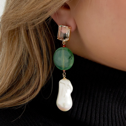 Groene oorhangers met facetgeslepen kristal en barok parel gedragen aan oor