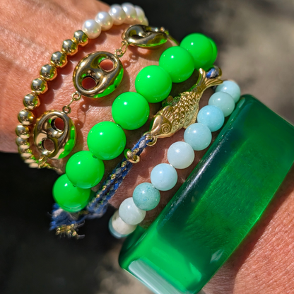 Arm van model met groene bangle armband, amazone stone kralen armband, vis armband, gifgroene kralenarmband varkens neus armband parel gouden kralen armband