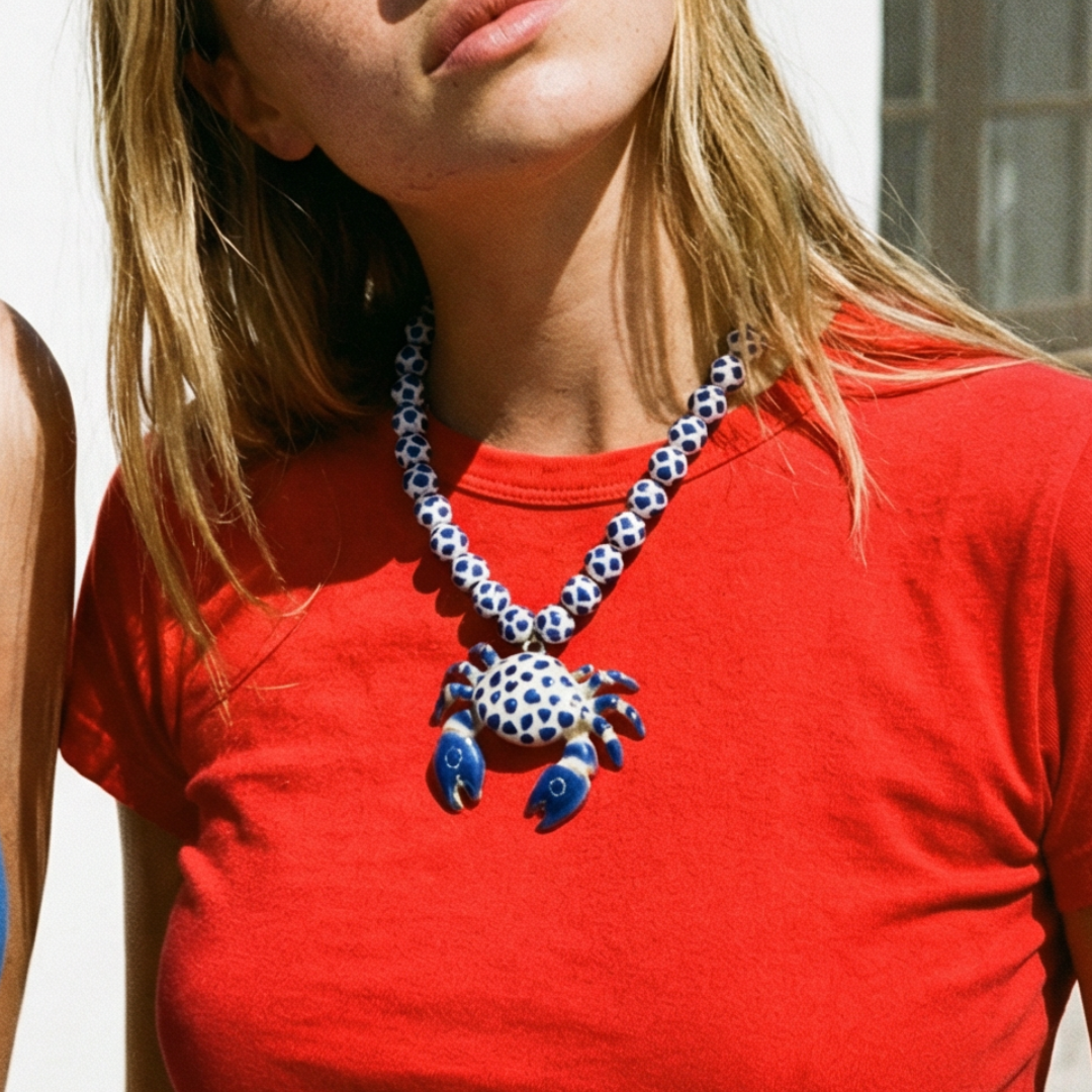 Wit-blauwe grote kralenketting met krab bedel gedragen door model. Casa Jadel