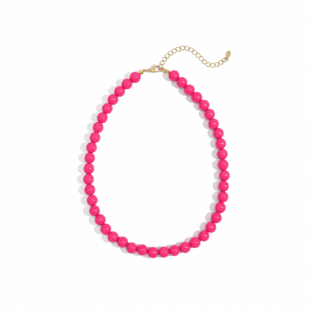 Hot Pink kralenketting Olivia met grote glanzende kralen en goudkleurige details.