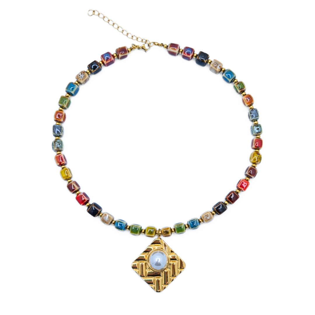 Keramiek kralenketting met gouden hanger en blauwe steen
