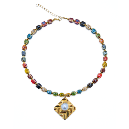Keramiek kralenketting met gouden hanger en blauwe steen
