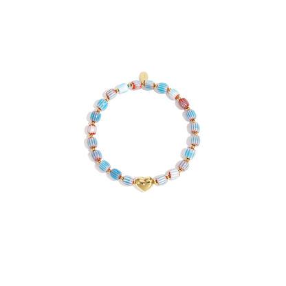Keramisch gestreept armbandje met roze en witte kralen en een goudkleurige hartjes bedel met strass, gefotografeerd op witte achtergrond.