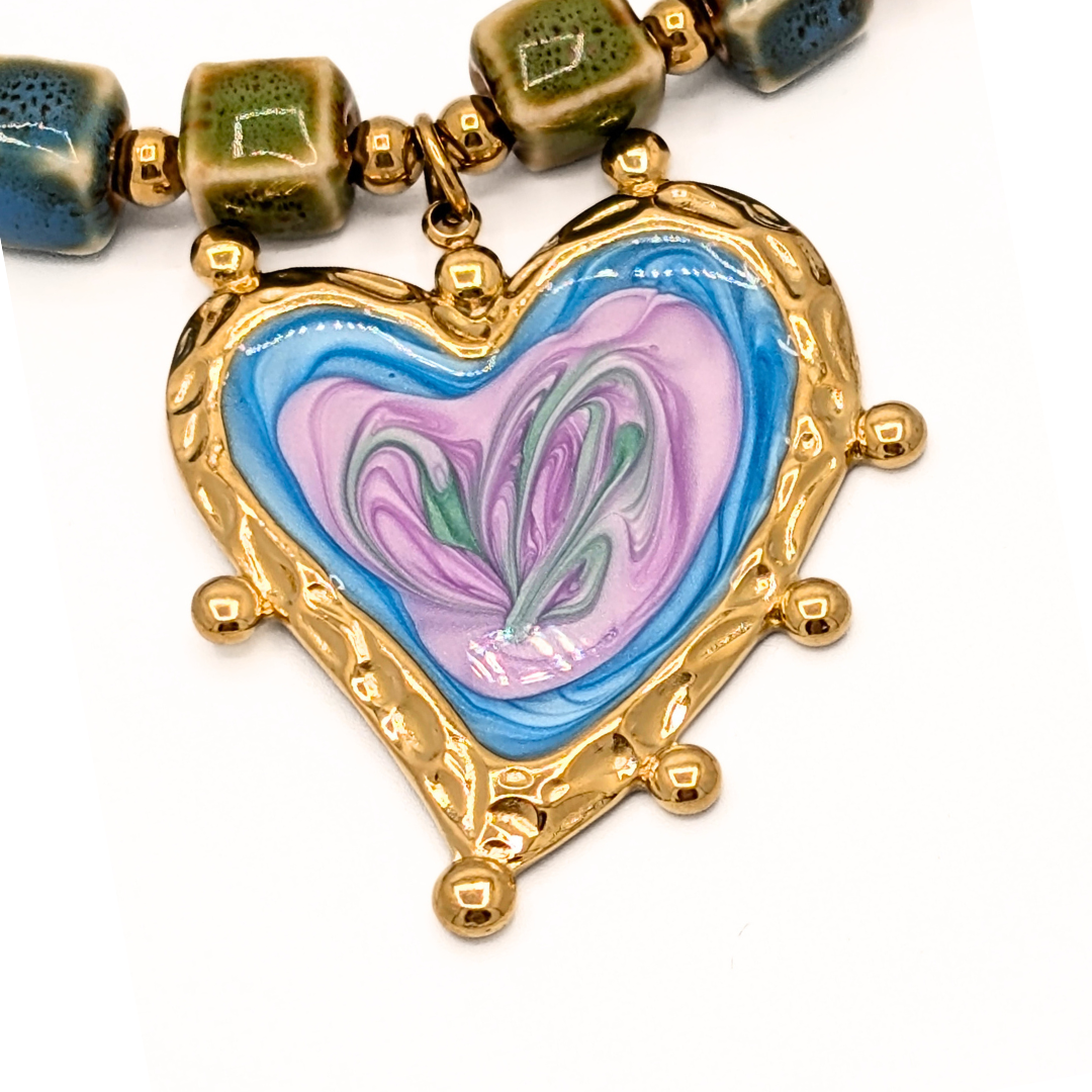 Detail van keramische kralenketting met gegalvaniseerd hart
