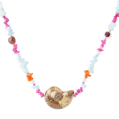 Kleurrijke natuursteen ketting met grote natuurlijke ammoniet hanger, lichtblauwe natuursteenchips, parels en roze-oranje accenten van Casa Jadel.