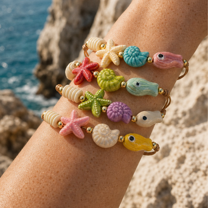 Model draagt kleurrijke zeedieren armbanden met schelpen vissen en zeesterren van Casa Jadel