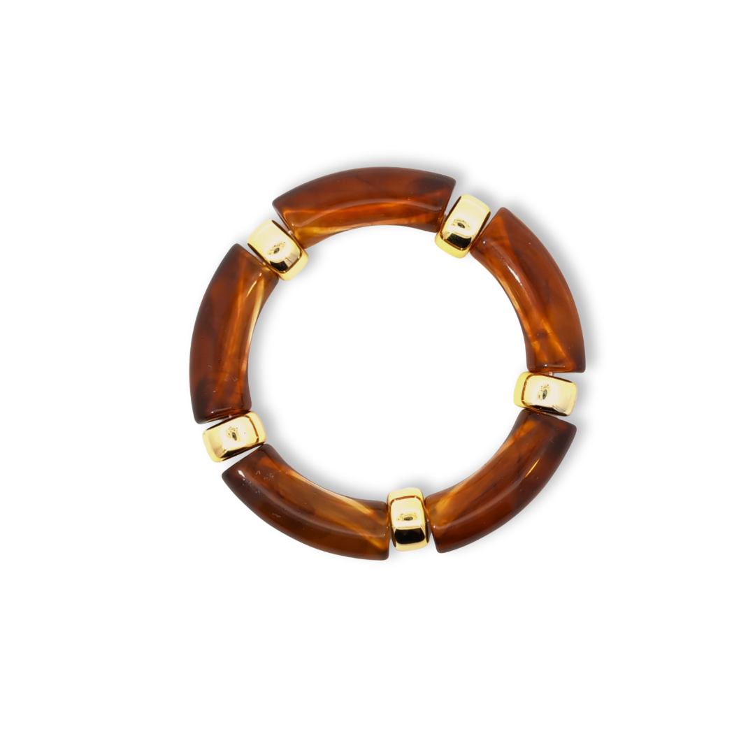 Koffie amber gemarmerde tube armband met goudkleurige details op witte achtergrond