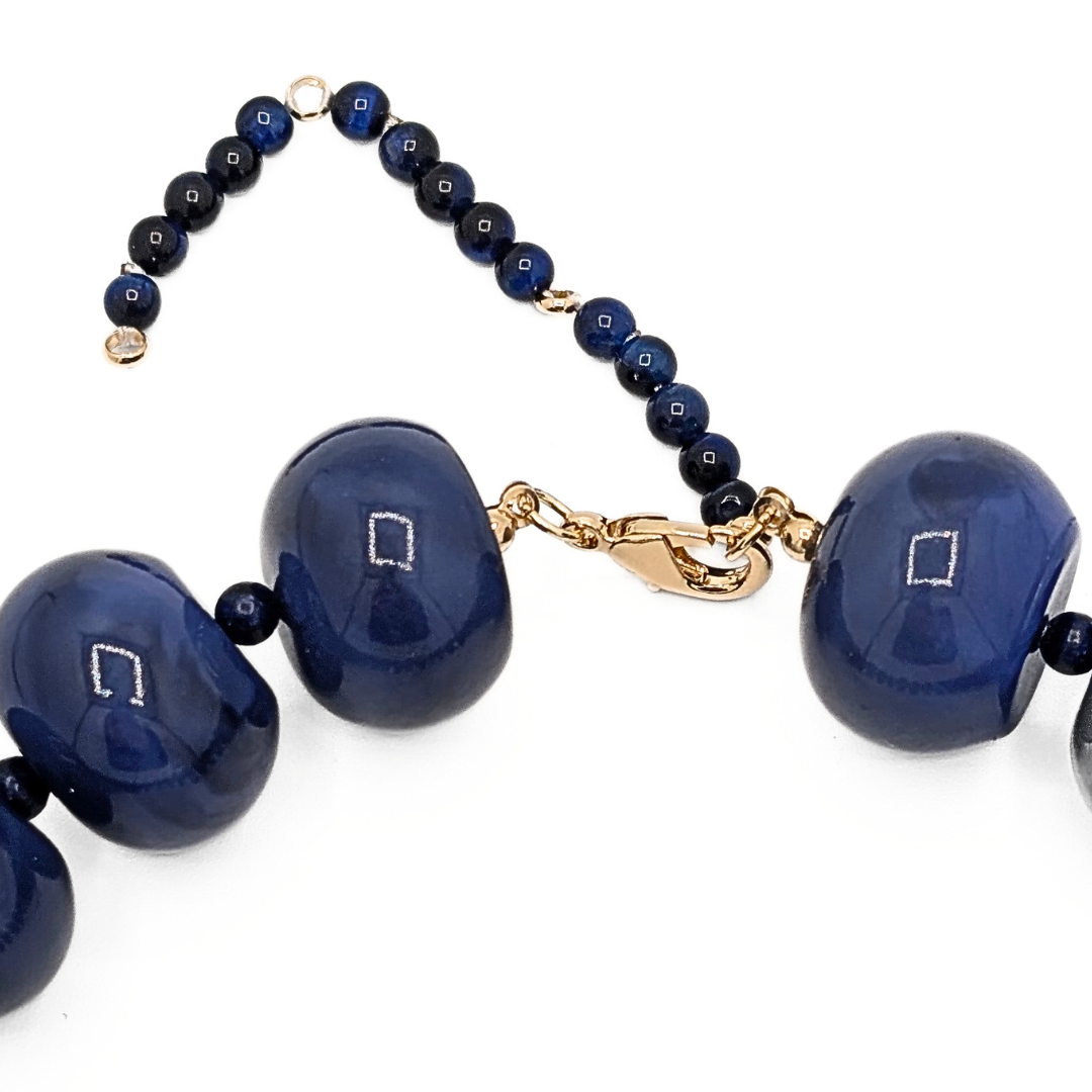 Detail van donkerblauwe kralenketting Lies met goudkleurige sluiting en verlengstuk met kleine kralen – Casa Jadel