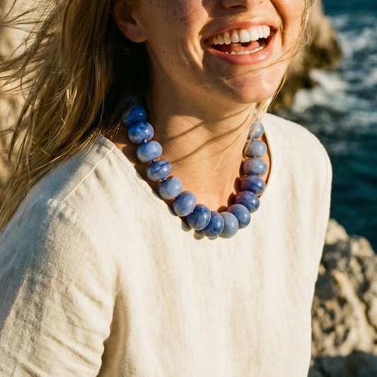 Kralenketting Lies in blauw gedragen door model bij de zee, zonnig.