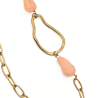 Detail lange gouden schakelketting met roze kralen en gouden schakels