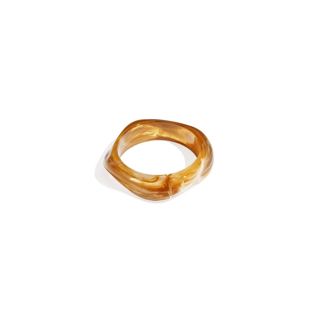 Licht amber asymmetrische resin bangle armband met subtiele marble-look van Casa Jadel.
