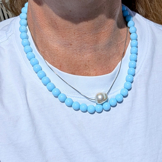 model met lichtblauw kralenketting dunne zilveren ketting statement parel
