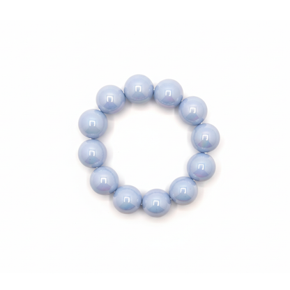 Lichtblauwe chunky kralenarmband met grote glanzende kralen op lichte achtergrond.