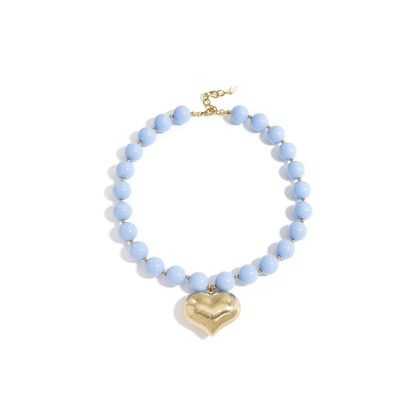 Lichtblauwe kralenketting met grote gouden chubby hartbedel en goudkleurige details