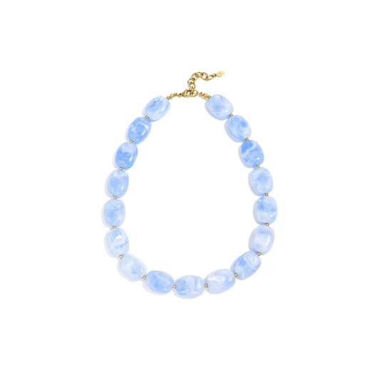 Blauwe kralenketting met marmerlook en gouden details op witte achtergrond