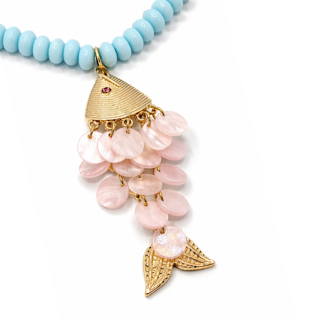 close up Lichtblauwe lange kralenketting met gouden vis bedel en schubben van natuurlijke schelp van Casa Jadel.