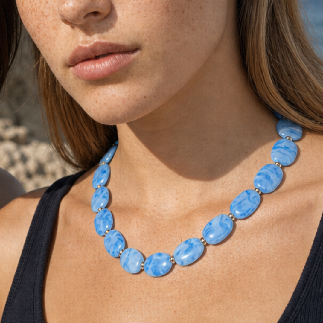Model draagt een lichtblauwe ovale kralenketting van Casa Jadel