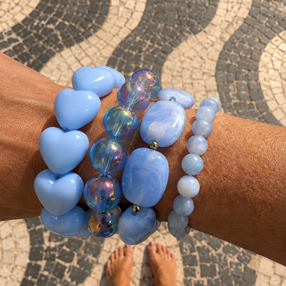 arm met lichtblauwe armbanden hartjes gemarmerd aquamarijn metalic