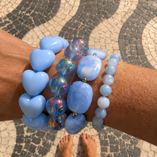 arm met lichtblauwe armbanden hartjes gemarmerd aquamarijn metalic
