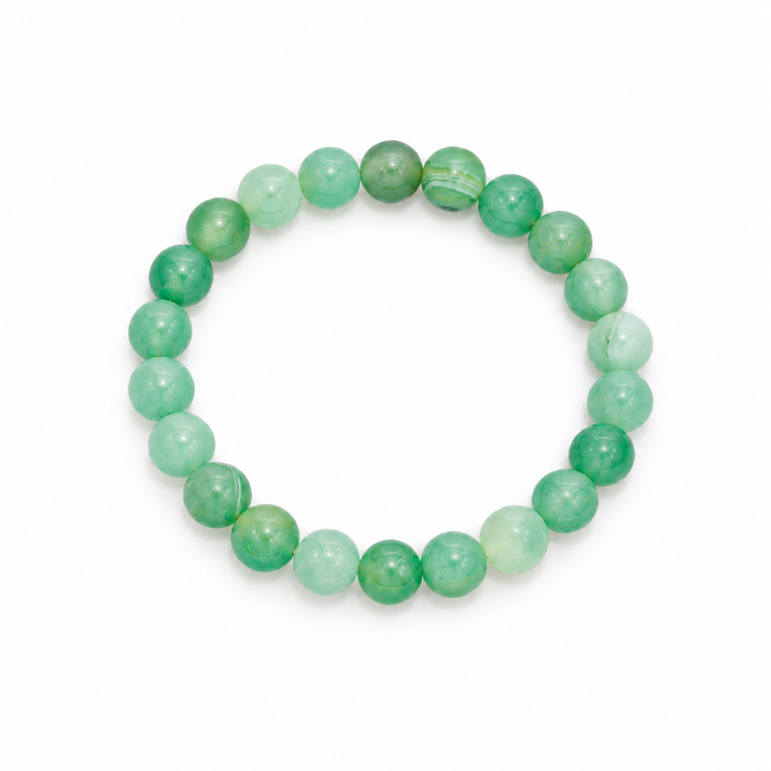 Lichtgroene jade natuursteen kralenarmband met ronde groene kralen op witte achtergrond.