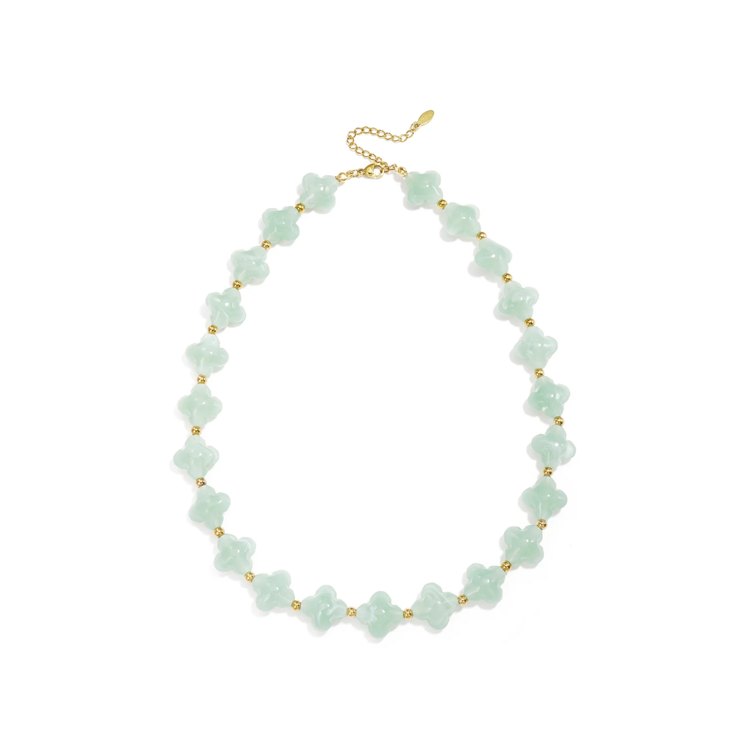 Mintgroene klavertjes kralenketting met gouden details en zachte pastel uitstraling