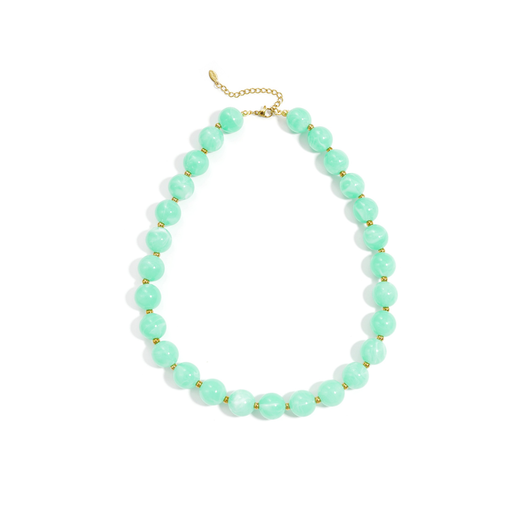 Mintgroene kralenketting met goudkleurige accenten op lichte achtergrond.