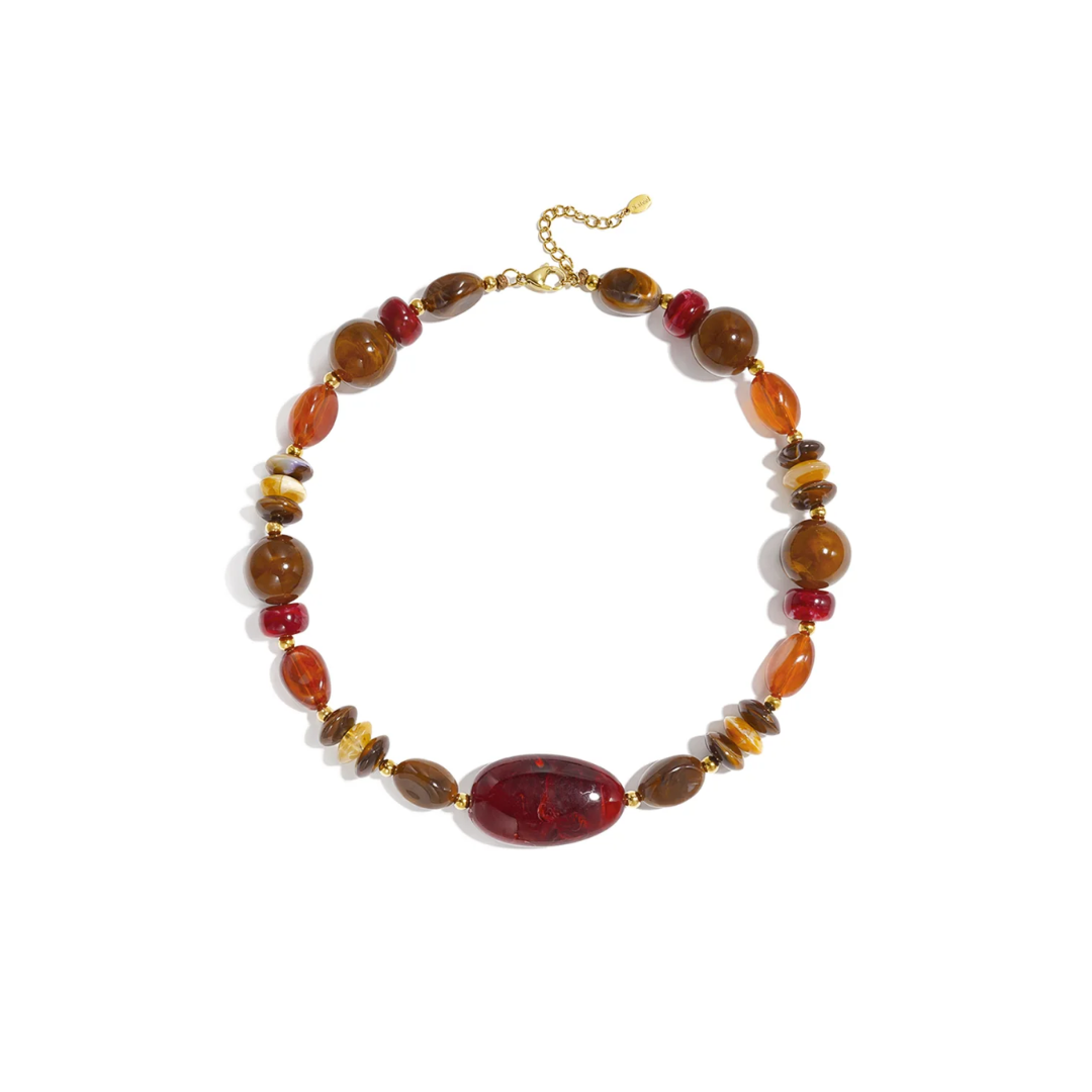 Mixed bruine kralenketting met grote burgundy statement kraal, amberbruine en transparante kralen, rode accenten en goudkleurige details