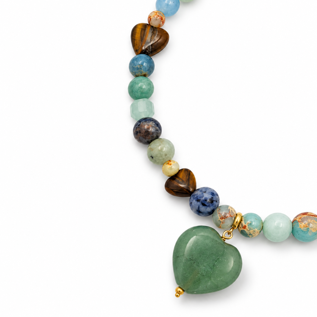 Mixed natuursteen kralenketting met blauwe, groene en bruine kralen, tijgeroog hartjes en een groene aventurijn harthanger met goudkleurige details.