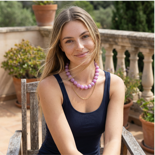 model met Hele grote babyroze kralenketting met grote ronde kralen en gouden sluiting op witte achtergrond