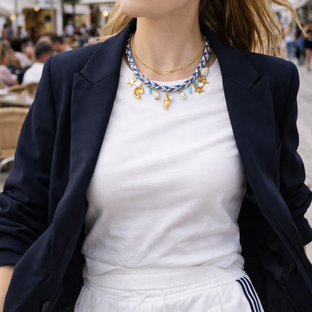 model met Blauwe gevlochten strandketting met schelp, zeester en parel bedels en gouden details. door de straten van ibiza