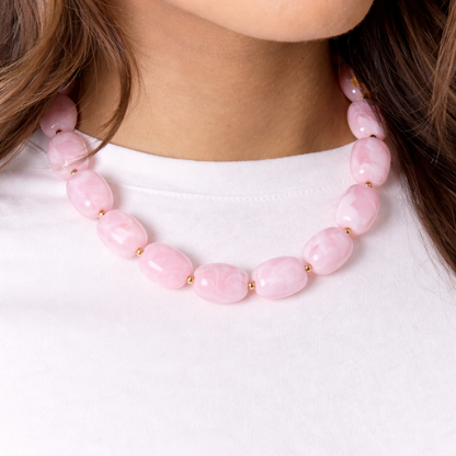 model met Roze kralenketting met marmerlook en gouden details