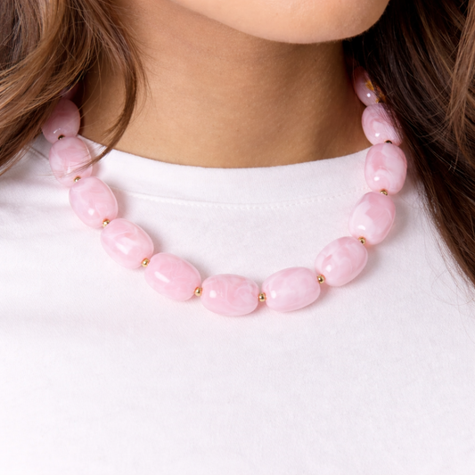 model met Roze kralenketting met marmerlook en gouden details