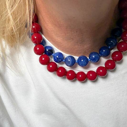 model  met blauw gemarmerde kralenketting  en rode ketting